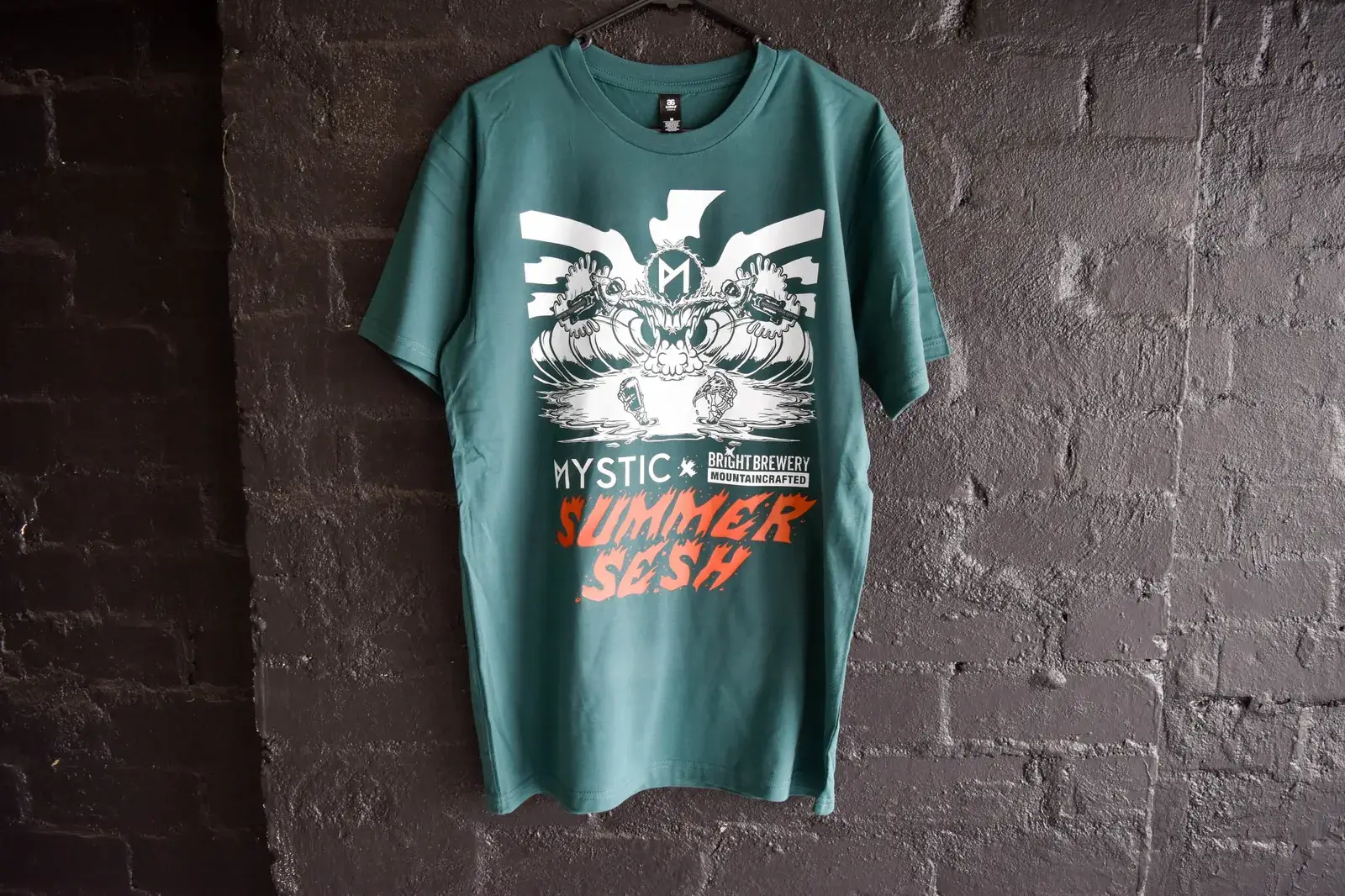 Bright Brewery Mystic Summer Sesh green tee on dark brick wall